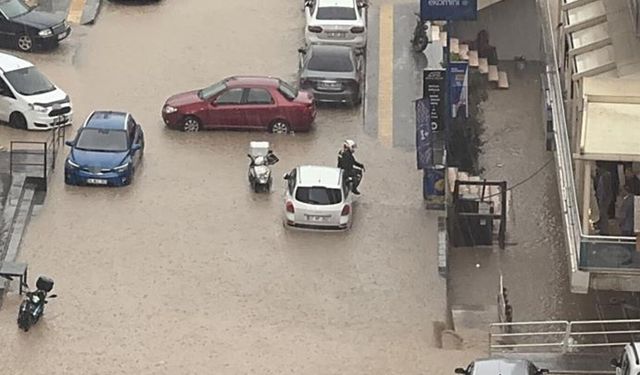 Sağanakta mahsur kalan sürücü çareyi otomobilin üzerine çıkmakta buldu